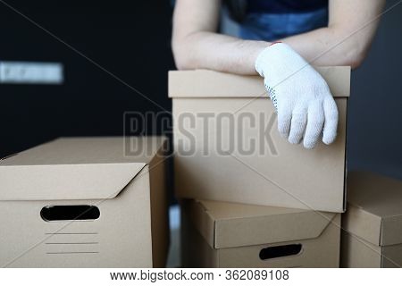 Gloved Hands Loader Lie On Cardboard Boxes Office. Relocation Service Packed Property In Separate Bo