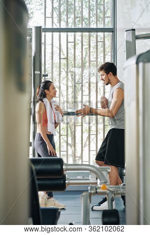Positive Fit Young Man And Woman Flirting After Exersicing In Gym