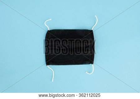 Black Face Protection Handemade Mask On Blue Background. Pandemic Or Epidemic Concept.