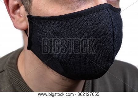 Black Protective Fabric Mask With Rubber Bands Wearing On A Face Close-up