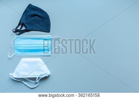 Different Protective Face Masks On Blue Background With Copy Space. Reusable Fabric Mask, Disposable
