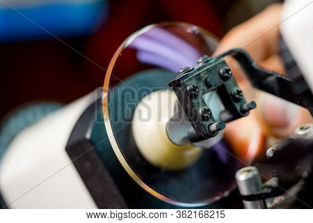 Glasses Manufacturing Process.health Care. Man Polishing Glasses In Optical Shop. Grind The Lens Int