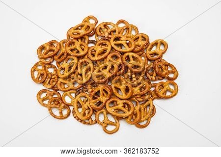 Salty Cracker Cookies In The Shape Of A Pretzel Sprinkled On A White Background. Oktoberfest Symbol 