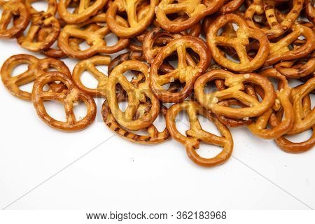 Salty Cracker Cookies In The Shape Of A Pretzel Sprinkled On A White Background. Oktoberfest Symbol 