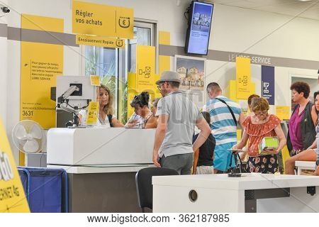 Cap Dagde, France - July 27, 2016: People Stand In A Queue For Post Office Services. Sending Parcel.