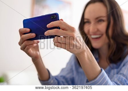 Closeup One Smiling Woman In Blue Shirt Talks On Phone, Video Calls, Takes Selfies, Online Game, Com