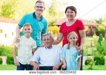 Portrait Of Big Happy Family With Old Grandfather, His Daughter And His Grandchildren At Nurising Ho