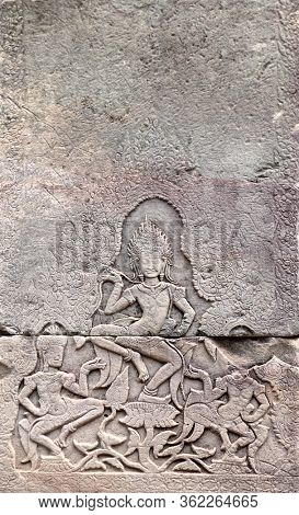 Wall carving with woman dancer apsara, famous Angkor Wat complex, Siem Reap, Cambodia. Vertical background with stone texture and bas-relief with dancing girls. Mock up template. Copy space for text