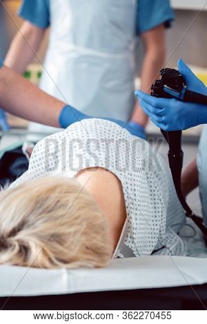 Patient and doctor in hospital during colonoscopy, closeup