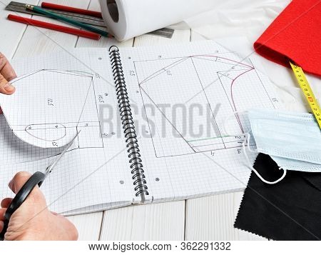 Female Hand Makes A Pattern For An Antiviral Mask During Isolation And Outbreak Of The Virus. Concep