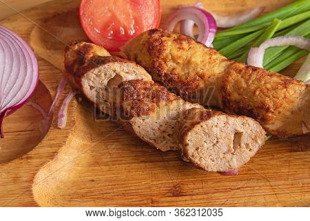 Turkey Lyulya Kebab On A Wooden Plate With Fresh Onions And Tomato Close-up. Dish Of Georgian Cuisin