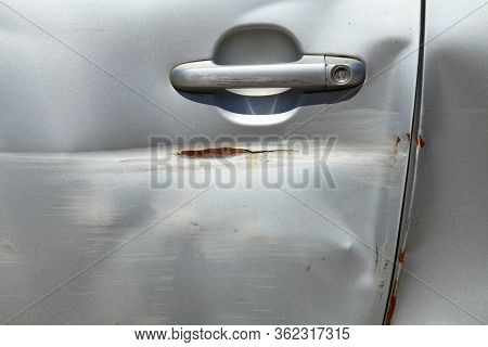 Fragment Of A Dented And Broken Door Of A Passenger Car. Accident Or Traffic Accident. Bad And Inept