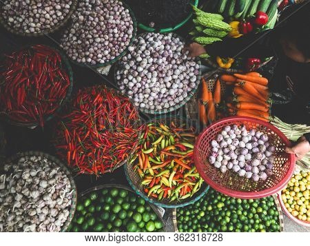 Hanoi, Vietnam, Febuary 1, 2020 - Fresh vegetables for sale at street food market in the old town.  Garlic, Lemon, Ananas, Onions, Peper, Red chillies, carots