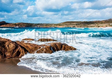 a view of the rock formations and the Mediterranean sea, with a strong swell, in La Marinedda beach, in Isola Rossa, Sardinia, Italy