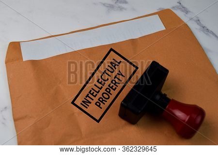 Red Handle Rubber Stamper And Intelectual Property Text Isolated On White Background.