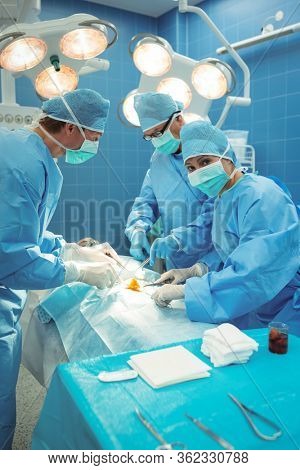 Team of surgeons performing operation in operation theater at hospital