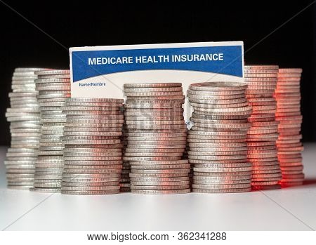 Many Stacks Of Old Silver Dimes With Medicare Health Insurance Card To Illustrate Budget Debt Fundin