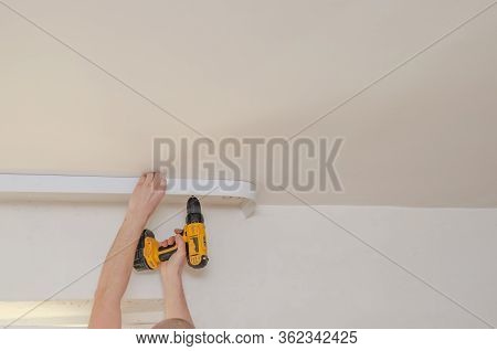 Fastening To The Wall Guide For Stretch Ceiling. Repairers Make Installation Of A Stretch Ceiling