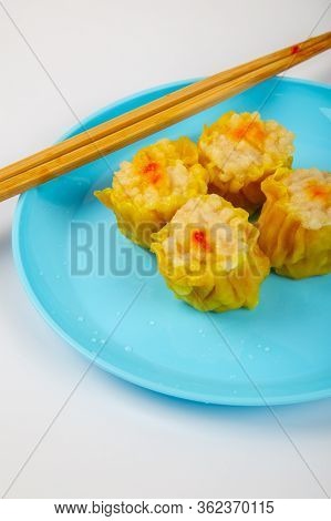 Siu Mai - Chinese Steamed Pork Dumplings On Blue Plate Isolated On White Background.