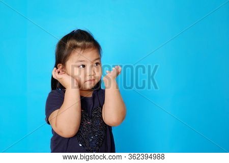 A Cute Little Asian Girl Is Listening To An Instruction From Her Teacher, Getting Ready To Cover Her