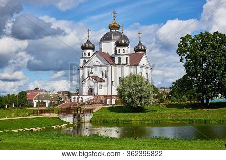 White Stone Orthodox Church On The Bank Of A Pond In The City Of Smorgon.