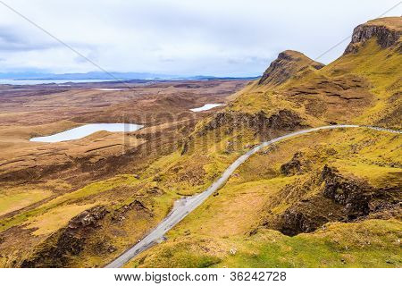 Estrada através das montanhas com o mar ao fundo