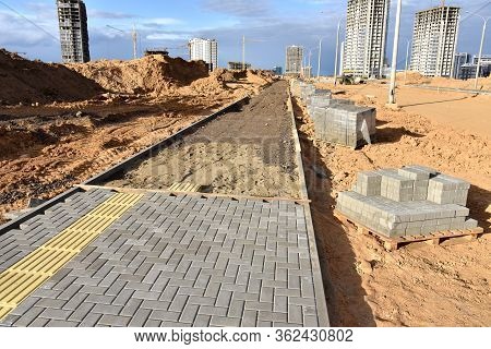 Laying Paving Slabs At Construction Site. Process Of Installing Paving Bricks In The Town Pedestrian