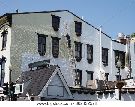 Washington Dc, Usa - June 4, 2019: A Painter Paints The Facade Of A Building In Georgetown.