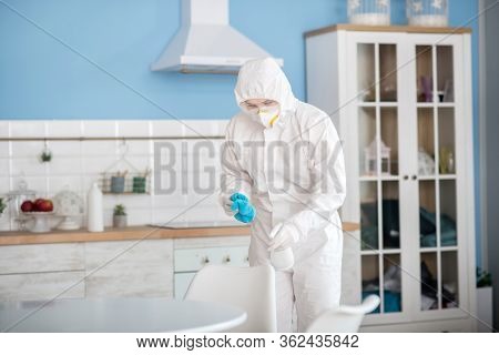 Woman In White Workwear Doing Disinfection In The Apartment