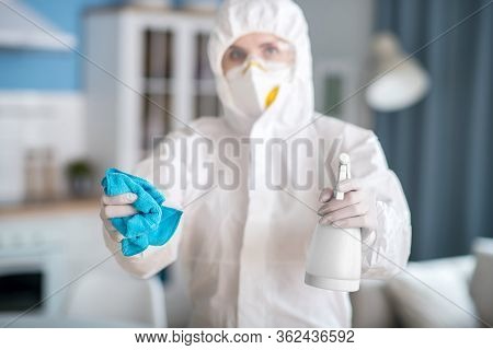 Woman In White Workwear And Protective Gloves Giving Antiseptic Liquid And A Duster