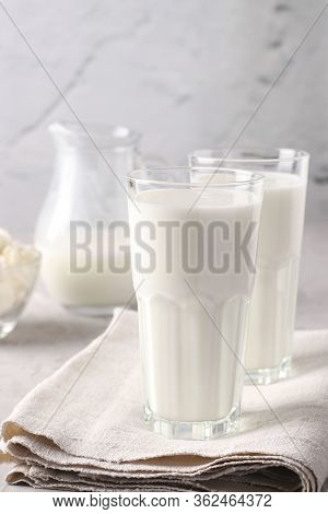 Kefir Or Ayran Fermented Drink In A Glasses And Jug, As Well As Cottage Cheese In A Bowl On Light Gr