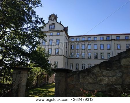 Sonnenstein Castle Behind Wall And Trees In Pirna, Germany