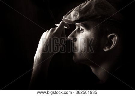 Sepia Side View Portrait Of Cute Young Guy With Moustache And A Hat On Black, Dark Background Smokin