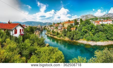Fantastic Skyline Of Mostar With The Mostar Bridge, Houses And Minarets, During Sunny Day. Location: