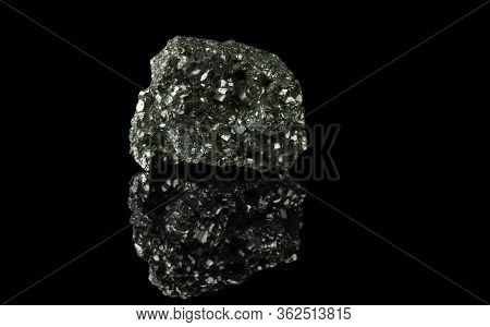A Cluster Of Pyrite Crystals. Isolated On A Black Mirror Background.