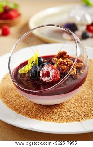 Berry Panna Cotta with Currant-Cointreau jelly in glass bowl. Creamy dessert with berries close up. Sweet meal, raspberry and blackcurrant souffle. Served gourmet appetizer, delicious restaurant food