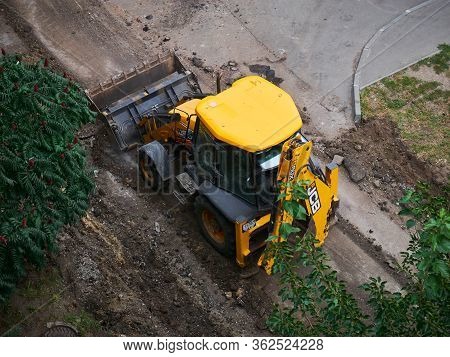 Kharkov, Ukraine - March 2020, Buldozer Is Reconstructing Asphalt Road Near The Civil Building. Hydr