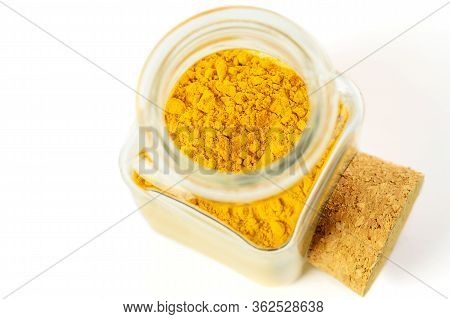 Turmeric Colorful Powder In Glass Bottle On The White Background Isolated. Anti-flu Remedy, Immunomo