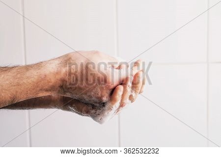Man Cleaning His Hands Using Liquid Disinfectant Soap And Water In Bathroom.