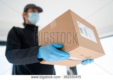 Home delivery shopping box man wearing gloves and protective mask delivering packages at door.