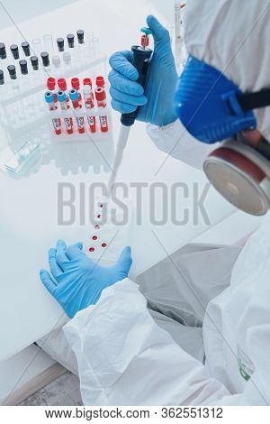 COVID-19. Doctor, microbiologist, scientist in a protective suit, makes a study of coronavirus in the laboratory. Coronavirus test.