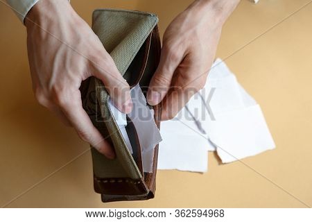 Empty Wallet With Paper Instead Of Money In The Hands Of A Man On A Light Monophonic Background, Top
