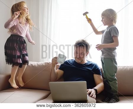 Tired Father With His Two Kids During Quarantine. Stay At Home Concept. Online Working And Household