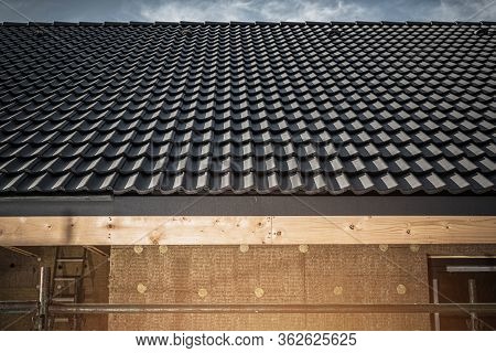 Roofing Project On New Constrcution Site. Dark Gray Shingles Installed On Roof.