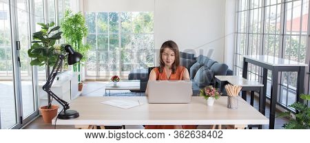 Beautiful Middle Age Asian Businesswoman Sitting At Desk And Using Laptop Notebook Computer In Apart