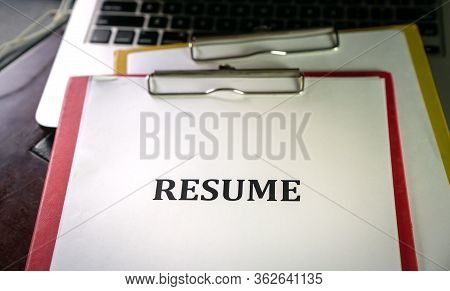Closeup Of Resume On Top Of Computer Laptop On Table With Pen