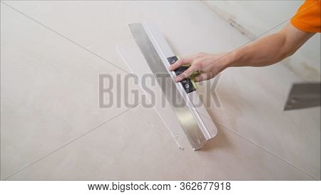 Plaster On A Wall. Worker Plastering The Walls With A Spatula.