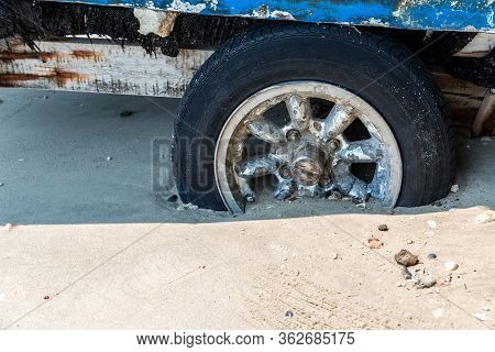 The Old Wheel Get Stuck In The Sands Of The Dunes In The Desert. Wheel In Countryside Landscape With