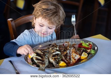 Fish For Food. Child Wuth Lemon And Fish Plate Meal. Dinner In Sea Restaurant. Seafood With Iodine F