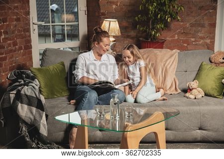 Reading Book. Mother And Daughter During Self-insulation At Home While Quarantined, Family Time Cozy